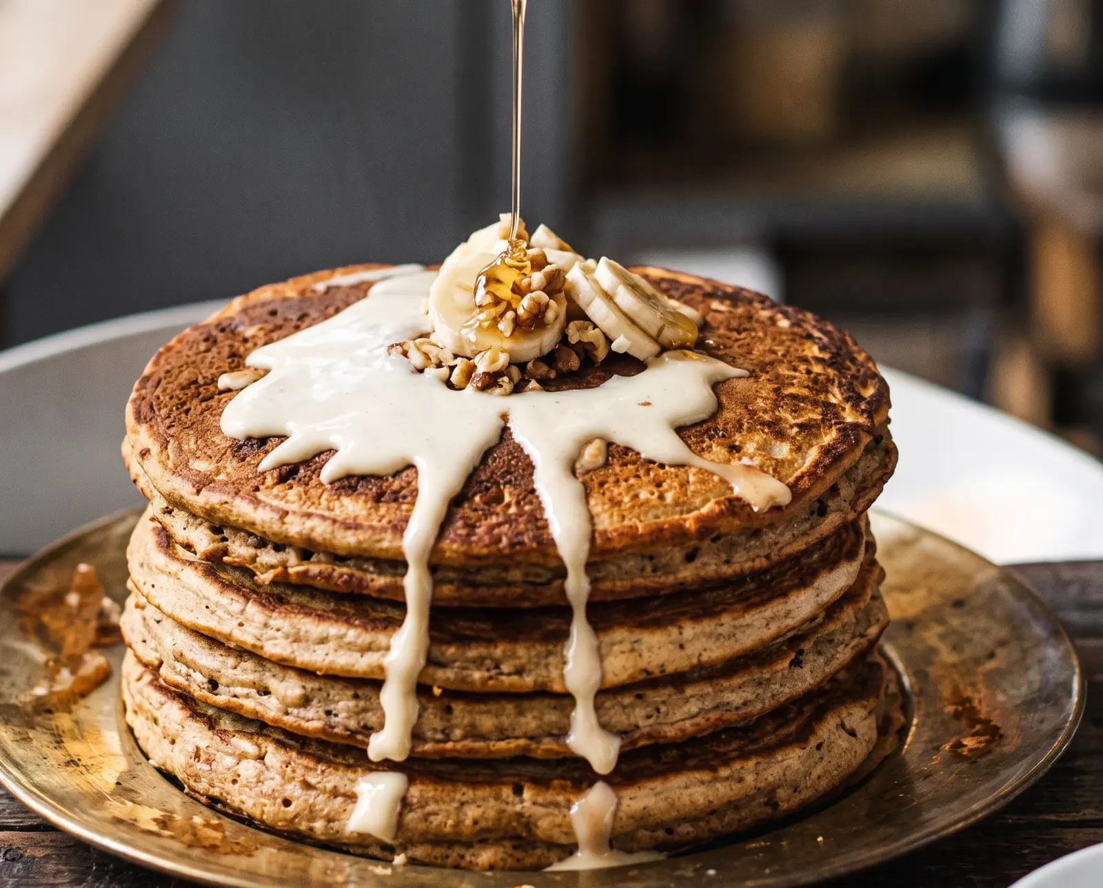 Stack of pancakes with banana and toasted nuts